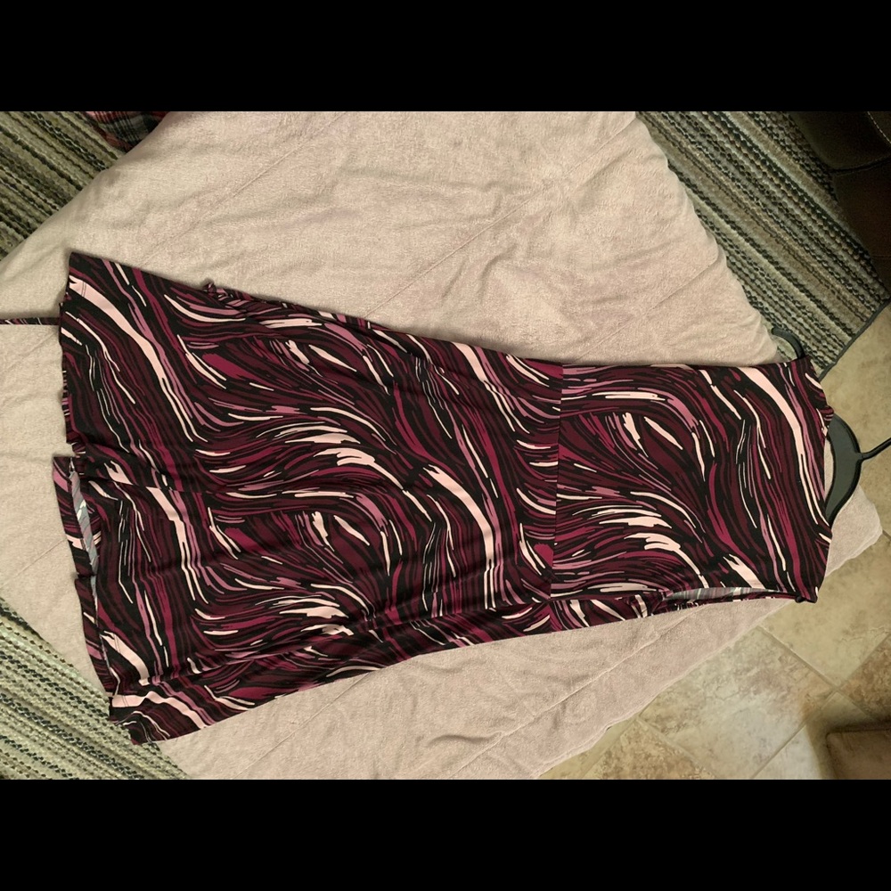 V-neckline with ruffle trim, sleeveless, cinched waist in good condition.